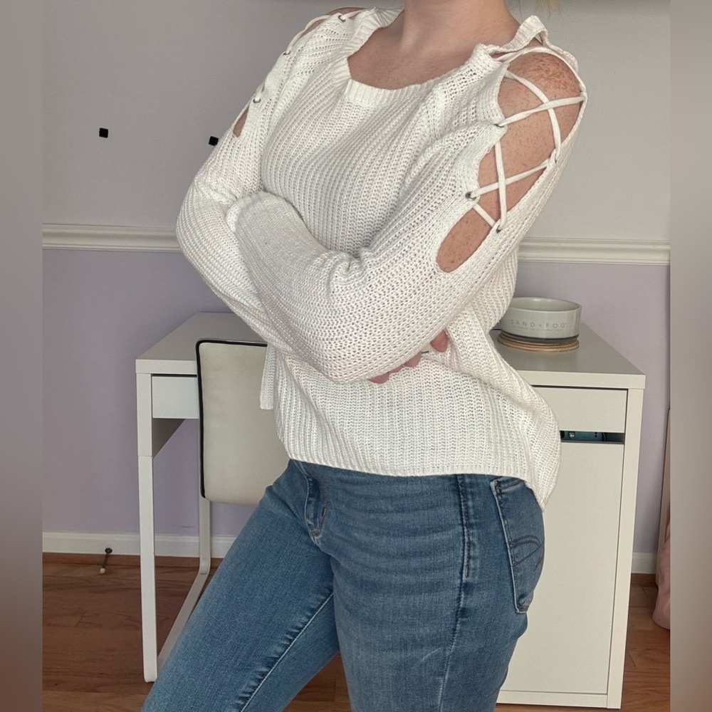 White knit sweater with cutout details and metal grommets
